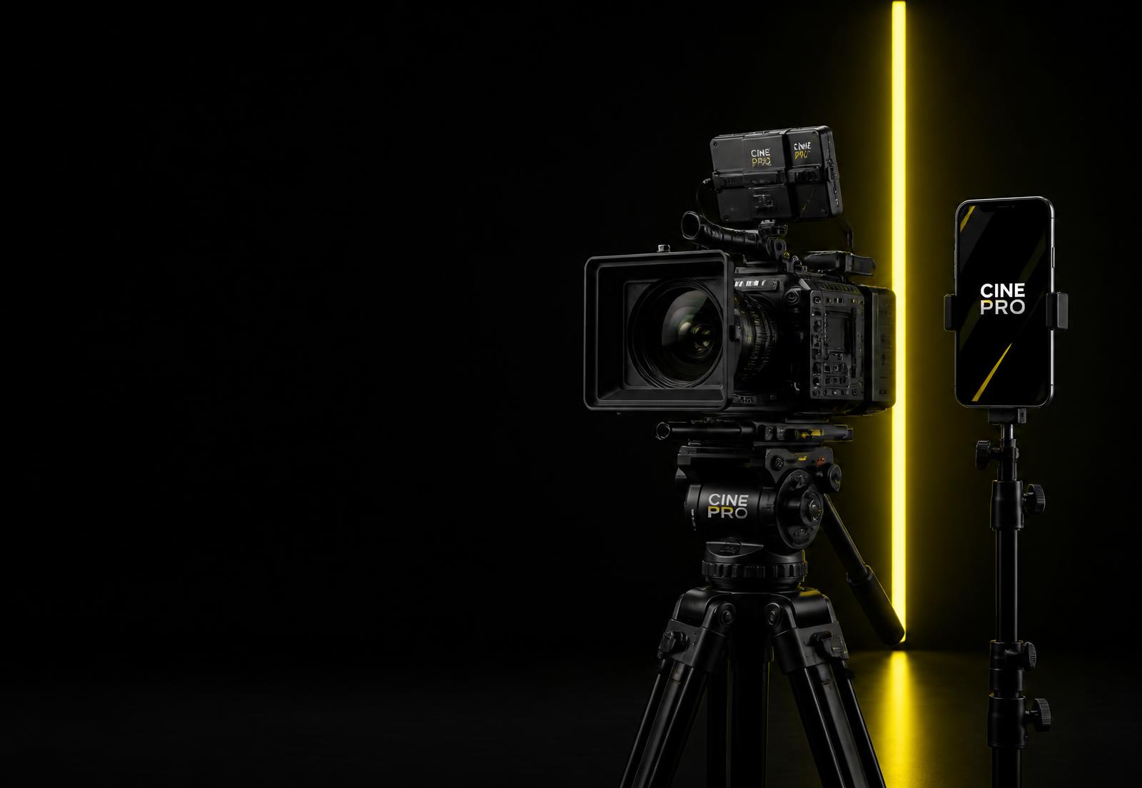 Cinema camera rig beside a phone playing a vertical social video on a dark studio set